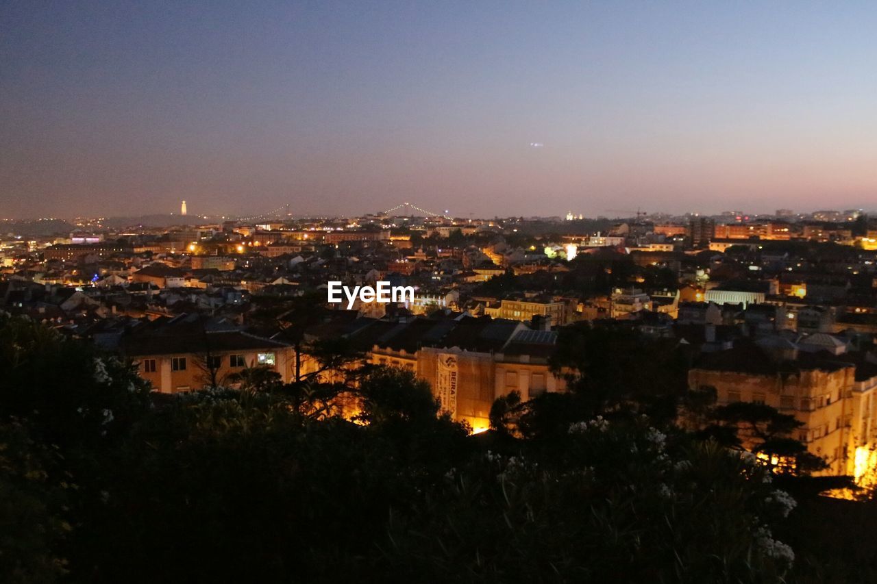 HIGH ANGLE VIEW OF ILLUMINATED CITYSCAPE AGAINST SKY AT NIGHT