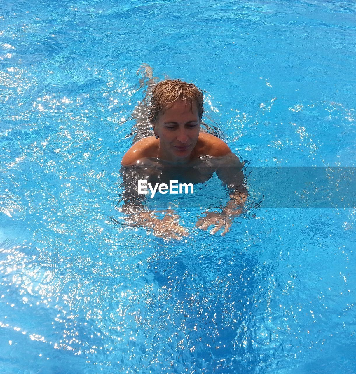 PORTRAIT OF SHIRTLESS YOUNG MAN SWIMMING IN POOL