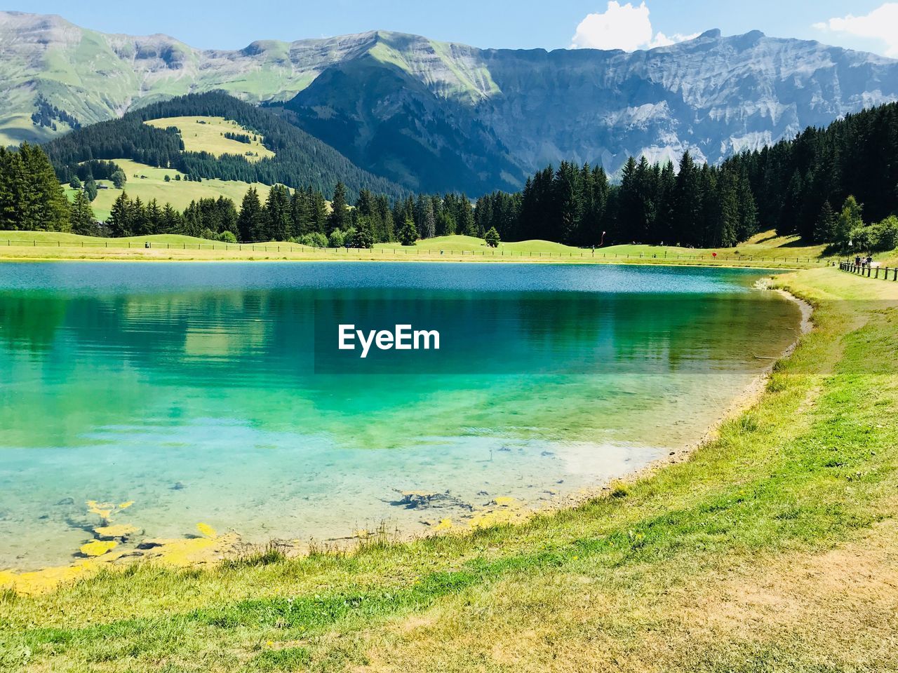 Scenic view of lake by mountains against sky