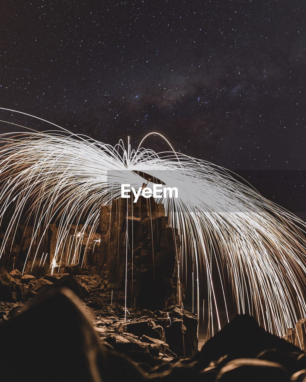 Low angle view of person spinning wire wool at cliff