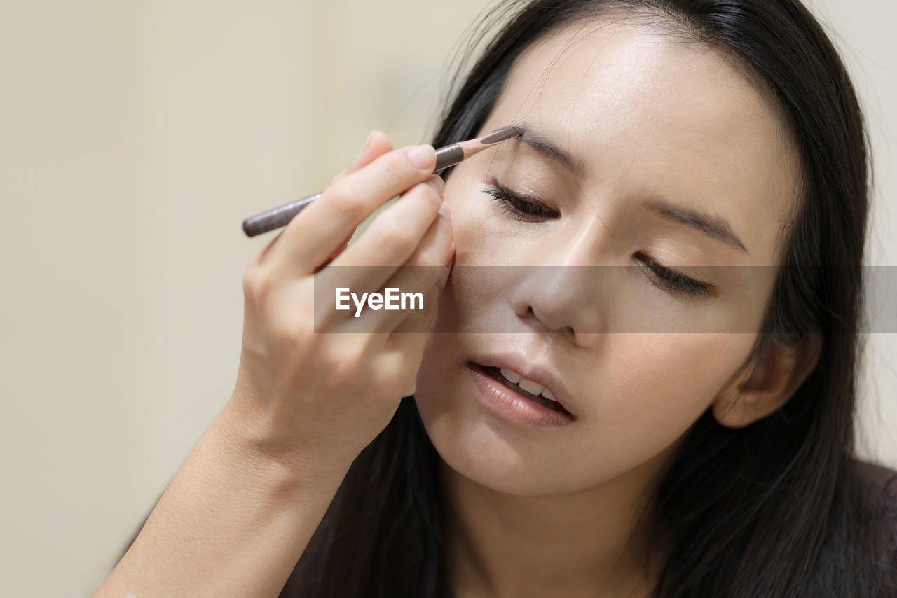 Close-up of woman applying make-up