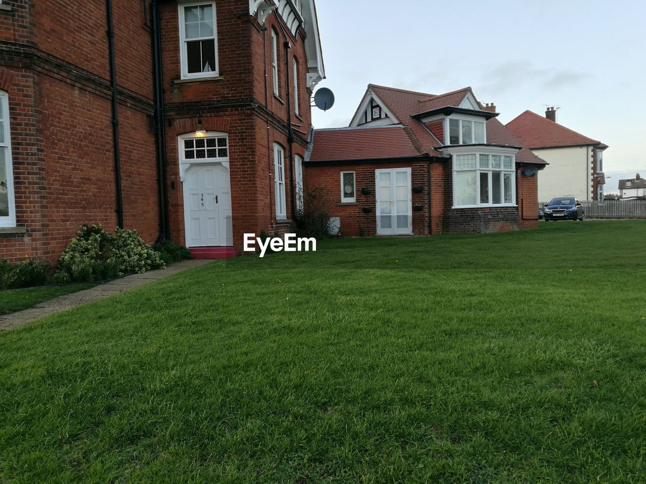 HOUSES ON FIELD AGAINST SKY