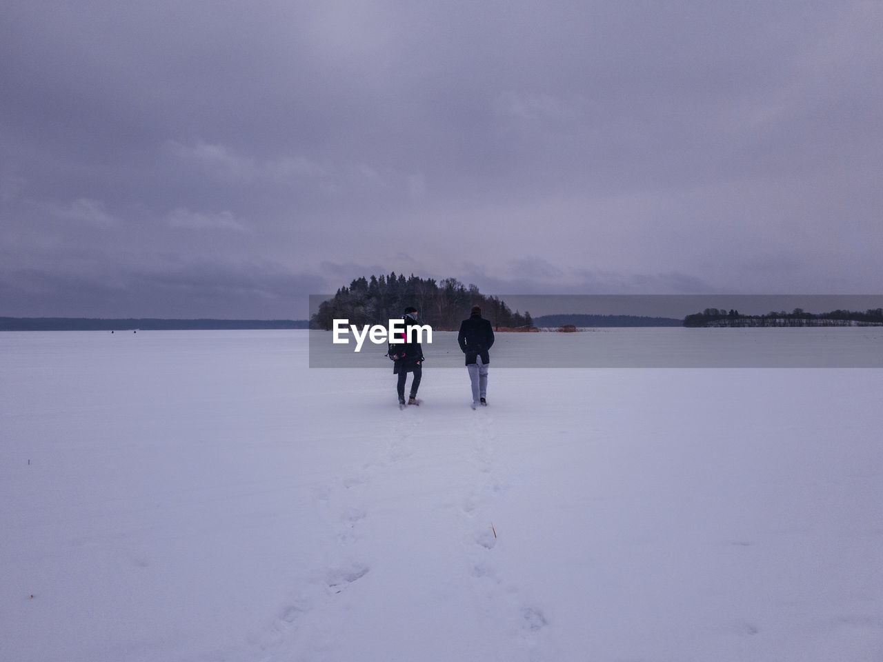 PEOPLE WALKING ON SNOW COVERED LANDSCAPE