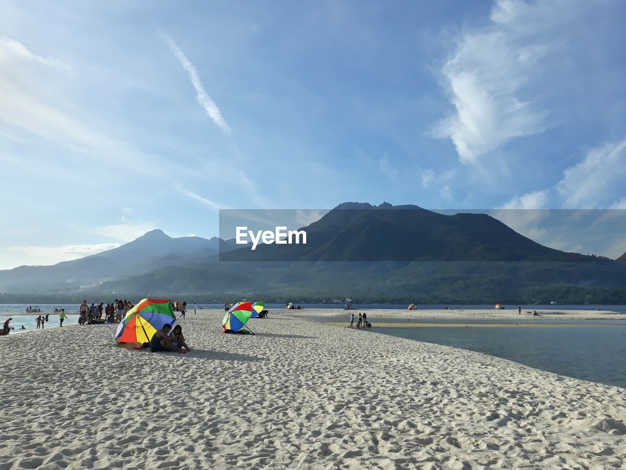 People on beach against mountains