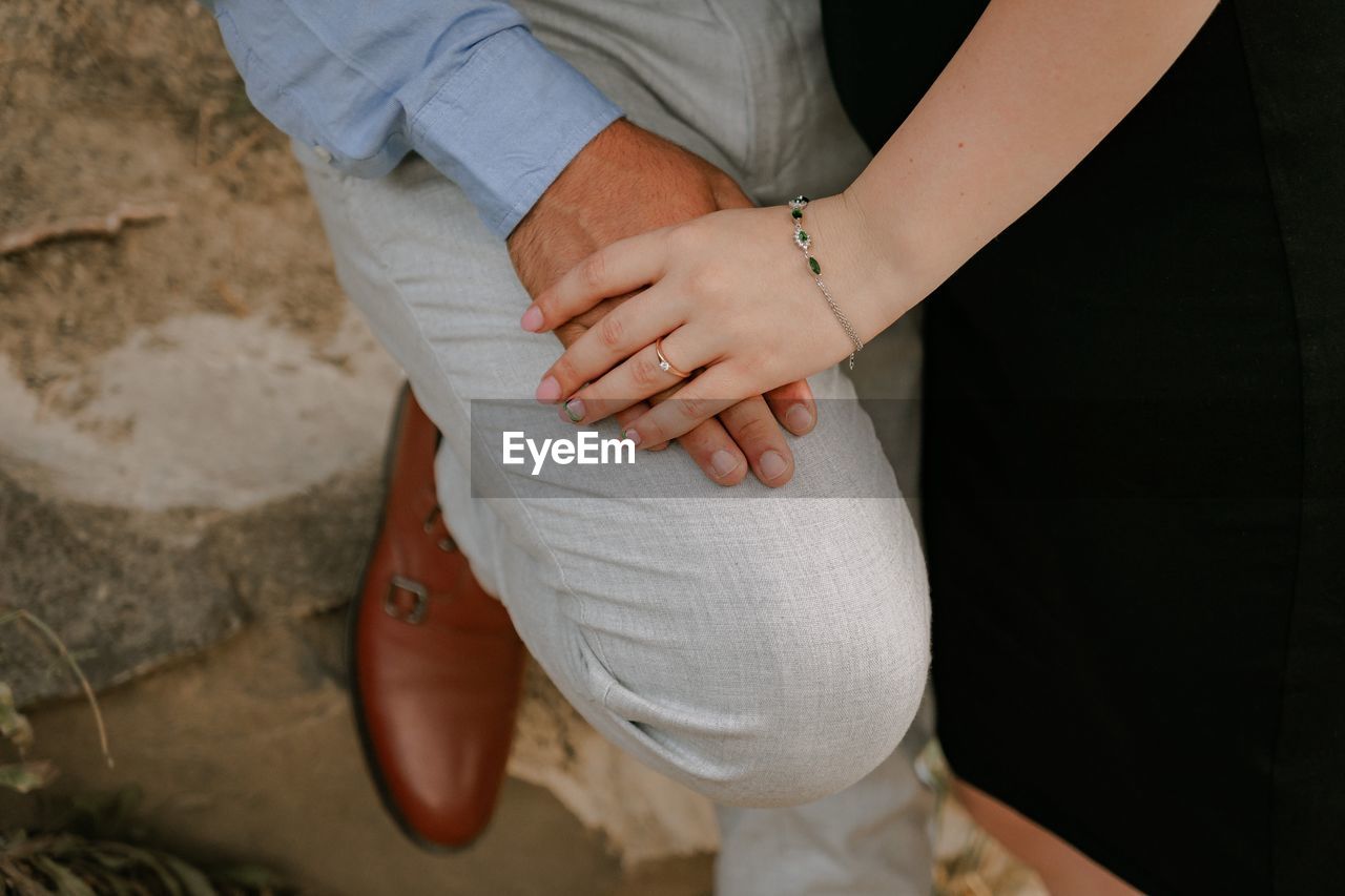 Detail of man and woman holding hands