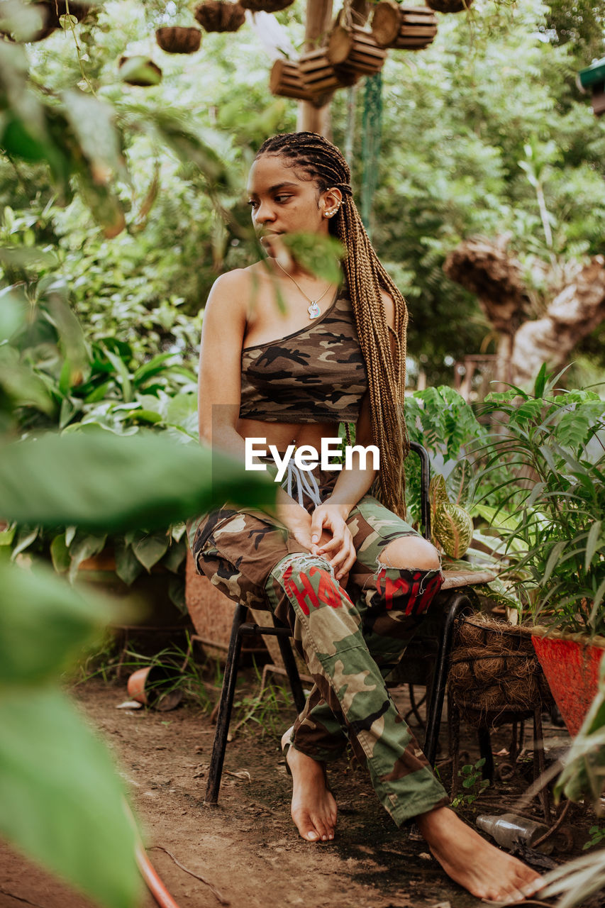 Woman standing by tree trunk