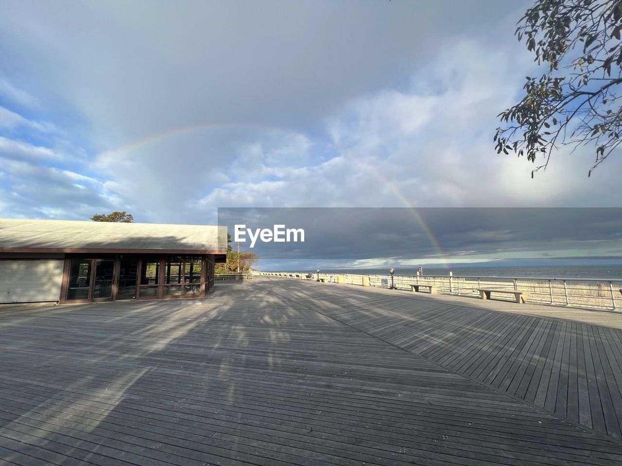 sky, rainbow, cloud, sunlight, horizon, architecture, nature, environment, built structure, water, beauty in nature, sea, scenics - nature, no people, morning, day, outdoors, boardwalk, landscape, building exterior, land, tranquility, transportation, coast, building, pier, travel, reflection, travel destinations, footpath, tranquil scene