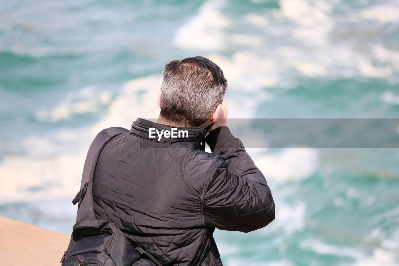 Rear view of man looking at sea