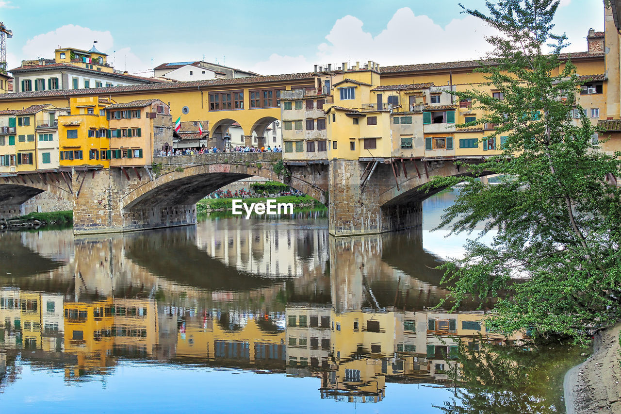 Bridge over river in city against sky