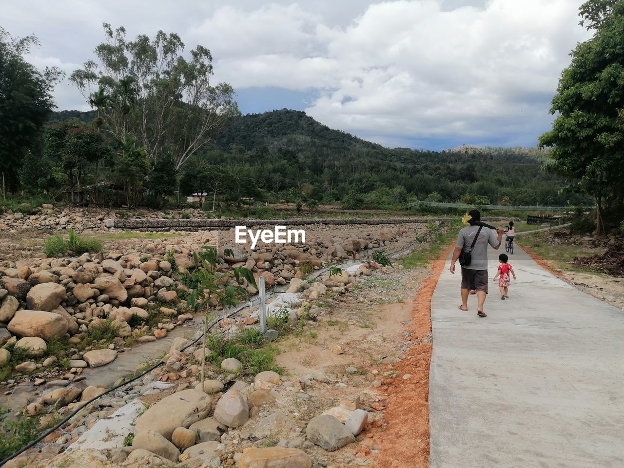 rear view of people walking on dirt road