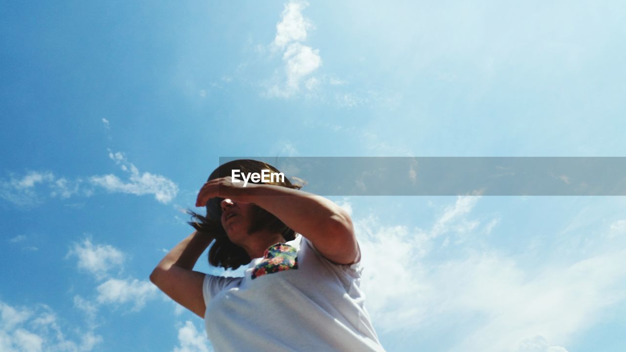 Low angle view of woman standing against sky