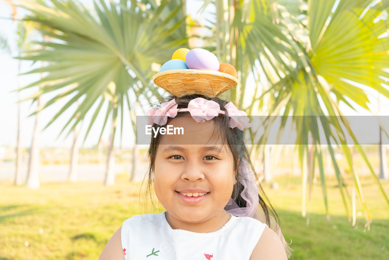 PORTRAIT OF A SMILING GIRL WITH PLANTS