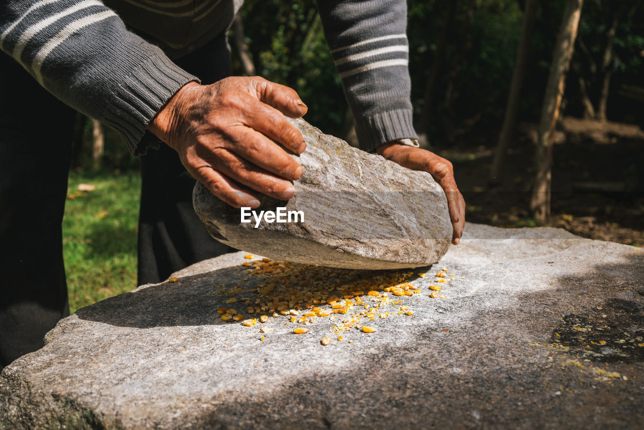 Close-up of man preparing food on millstone