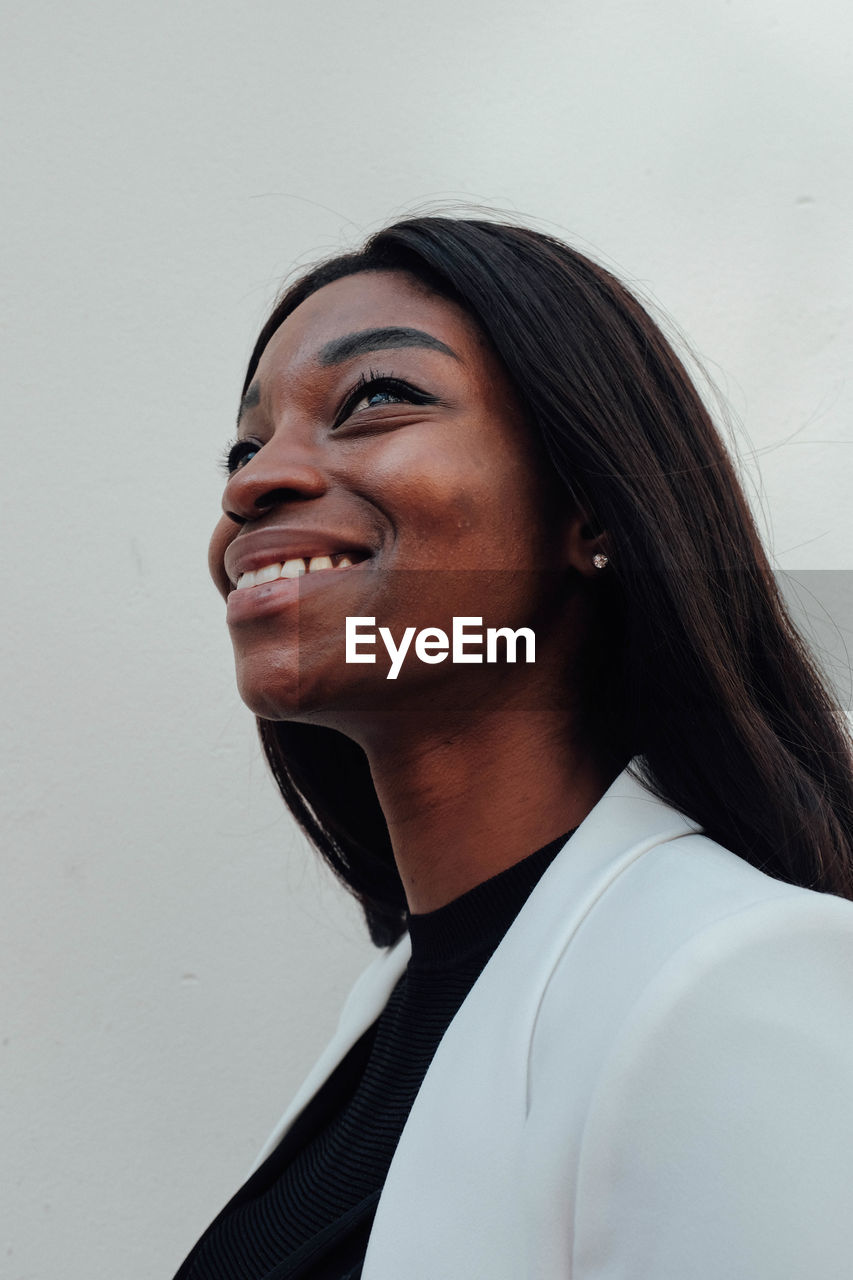 Close-up of smiling woman against white background