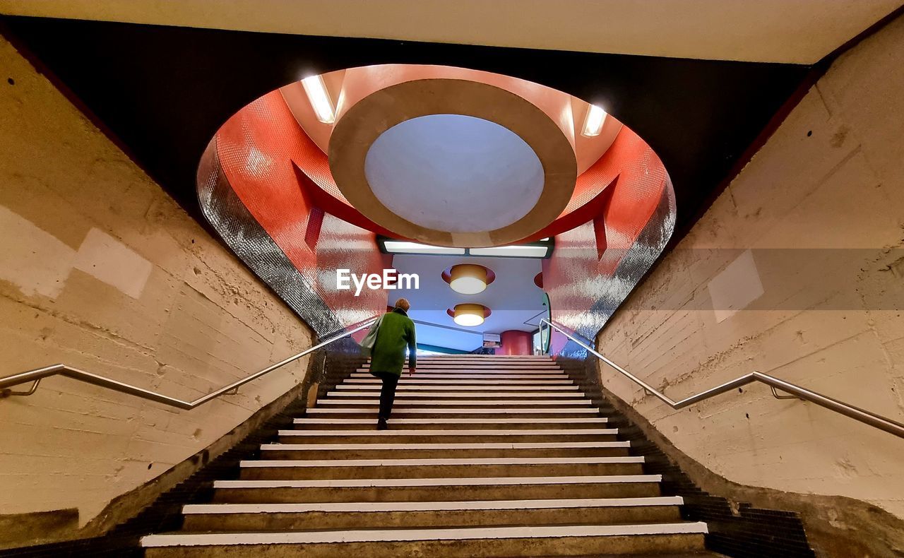 LOW ANGLE VIEW OF STAIRCASE IN ILLUMINATED SUBWAY