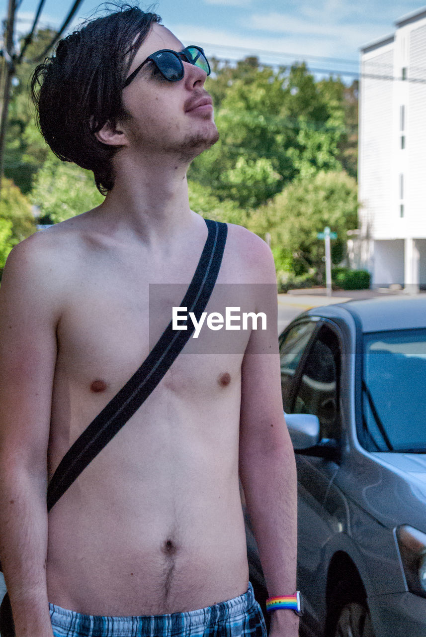MIDSECTION OF SHIRTLESS MAN WEARING SUNGLASSES