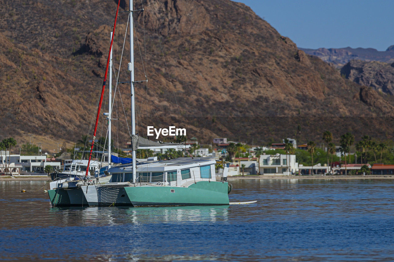 water, sea, nautical vessel, bay, mountain, transportation, ship, boat, vehicle, nature, mode of transportation, land, coast, no people, harbor, watercraft, beach, travel, environment, architecture, waterfront, sky, day, moored, travel destinations, scenics - nature, sailboat, beauty in nature, outdoors, boating, landscape, built structure, coastline, mast, tourism, rock, mountain range, building, tranquility, building exterior