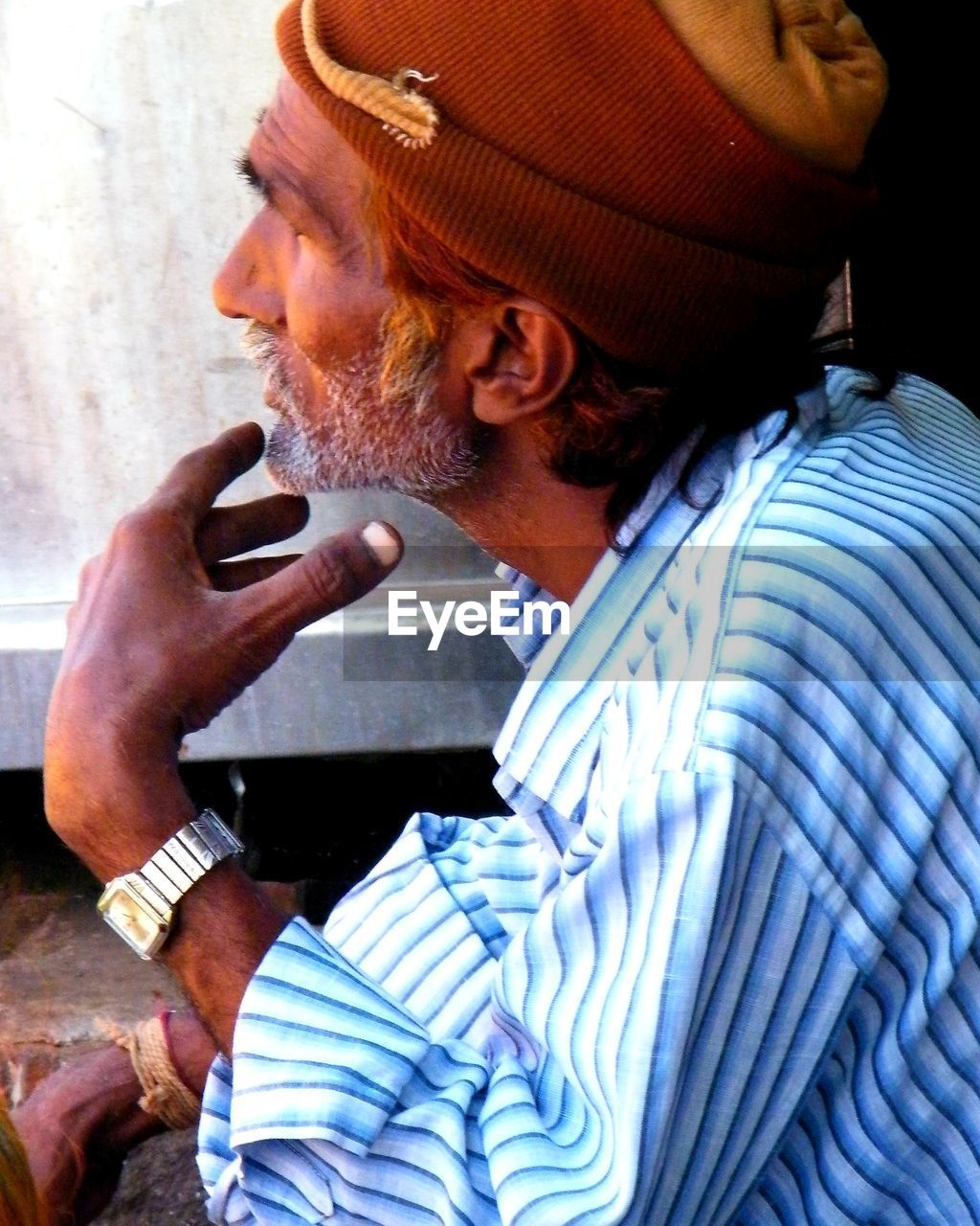 SIDE VIEW OF YOUNG MAN USING LAPTOP PHONE