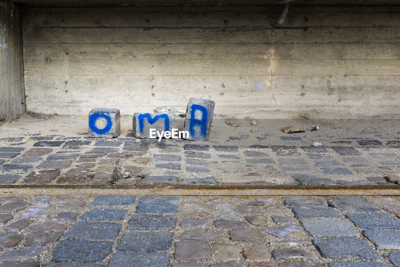 Concrete blocks with blue paint text against wall