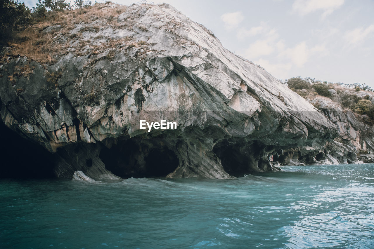 ROCK FORMATIONS IN SEA AGAINST SKY