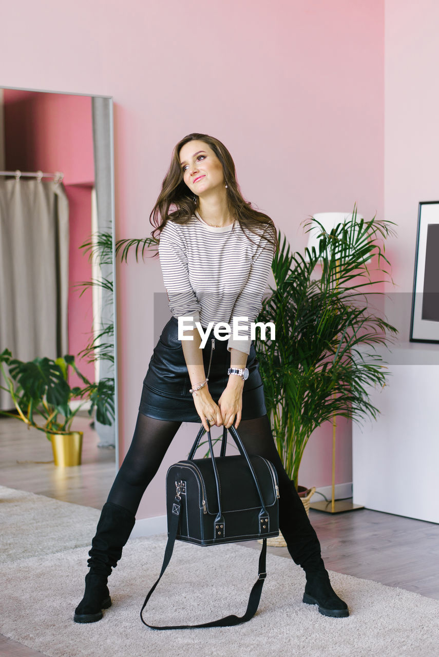 Cute caucasian young woman makeup artist holds a bag with a tool and makeup cosmetics in her hands