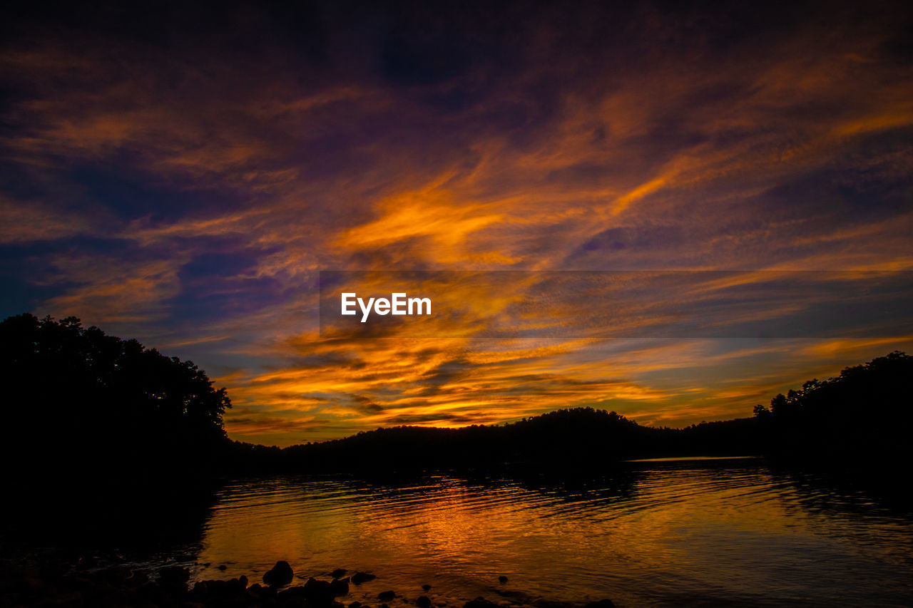 Scenic view of lake against orange sky