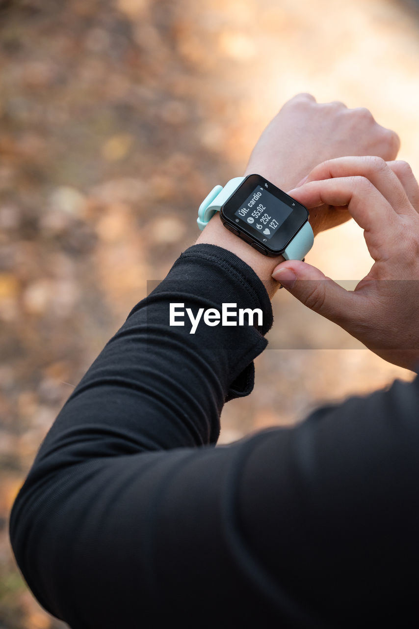 Girl checking smart watch with fitness tracker, looking at health data while exercising