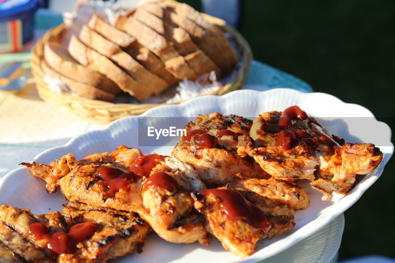 Close-up of grilled meat in plate on table during sunny day