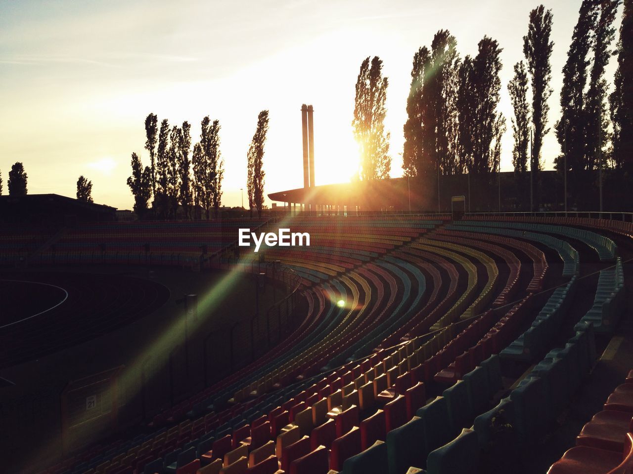 Empty chairs in stadium during sunset
