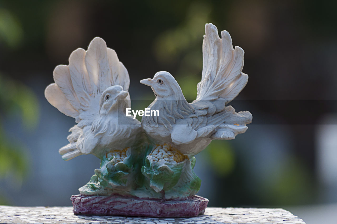 Doves watching over a gravestone. cemetery figurine. aged marble