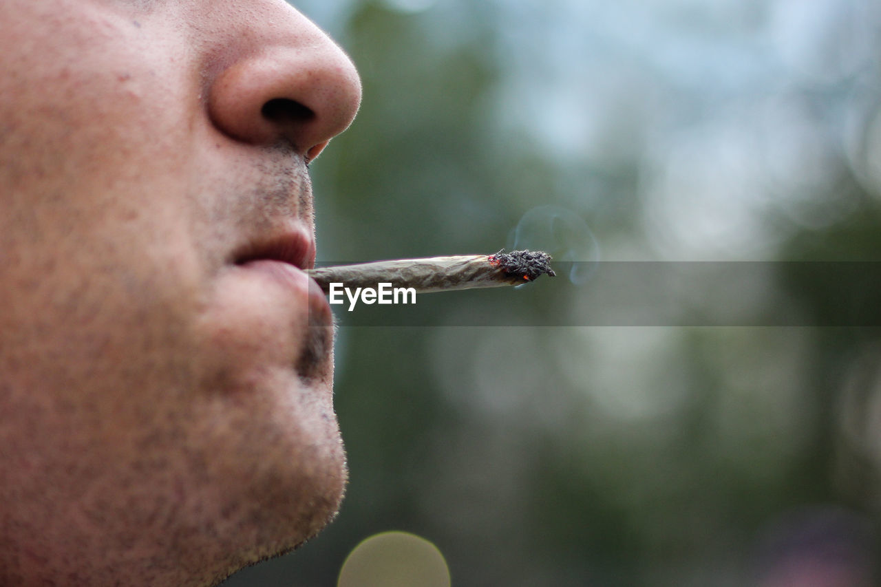 Close-up of man smoking marijuana joint