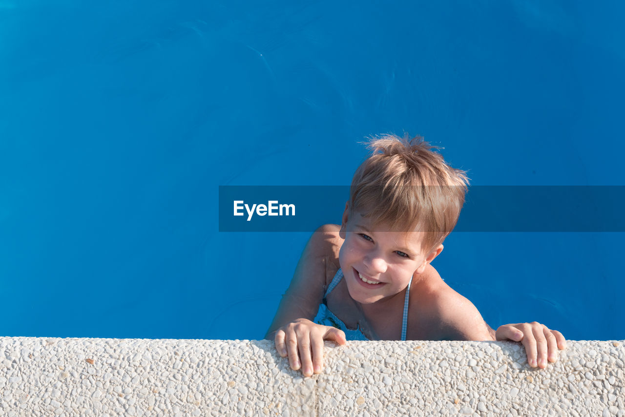 Portrait of cute boy in swimming pool