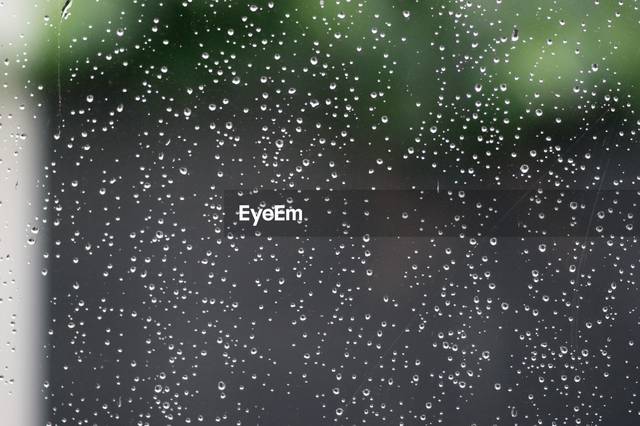 FULL FRAME SHOT OF RAINDROPS ON WET GLASS