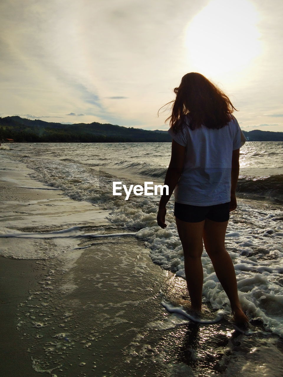 Girl walking at beach during sunset