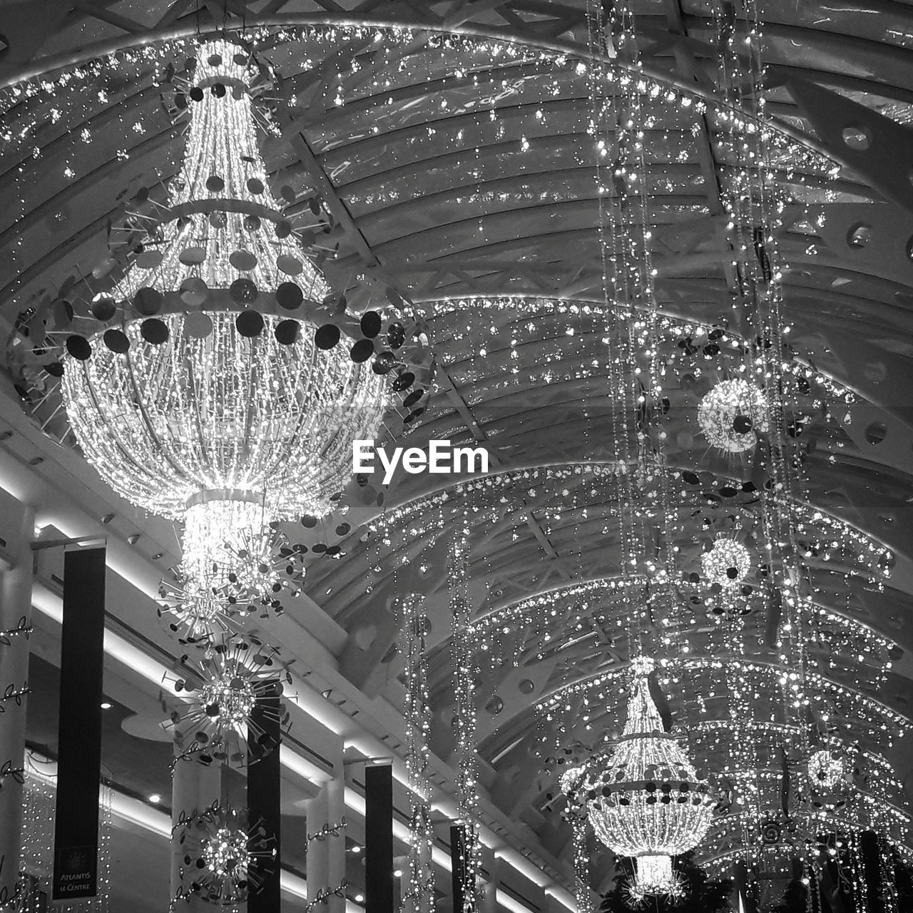 LOW ANGLE VIEW OF ILLUMINATED CHANDELIER HANGING ON CEILING