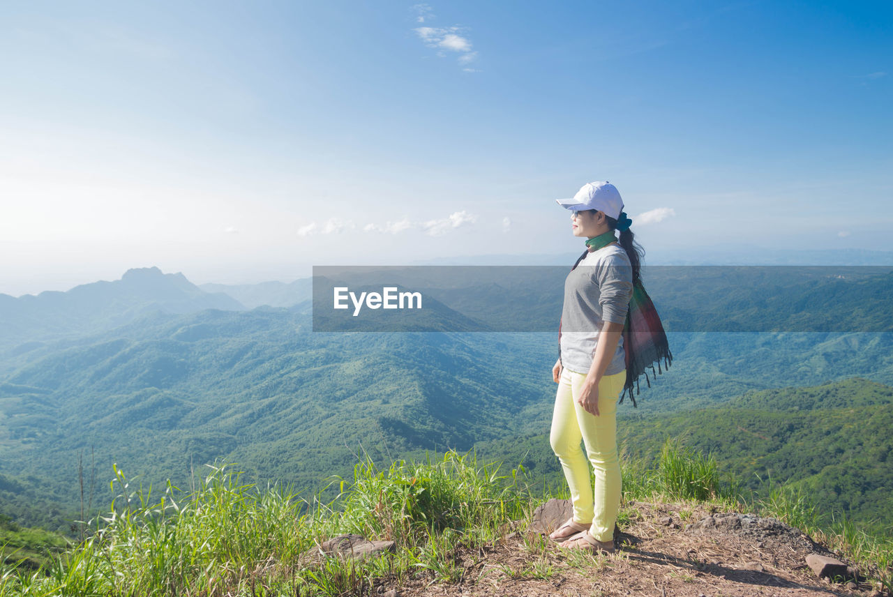 Full length of woman standing on mountain against sky