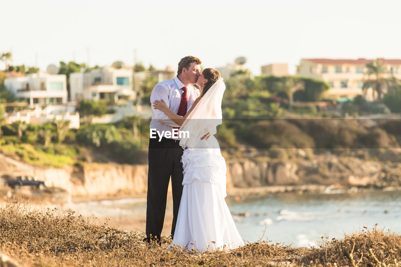 COUPLE STANDING IN FRONT OF MOTHER AND DAUGHTER