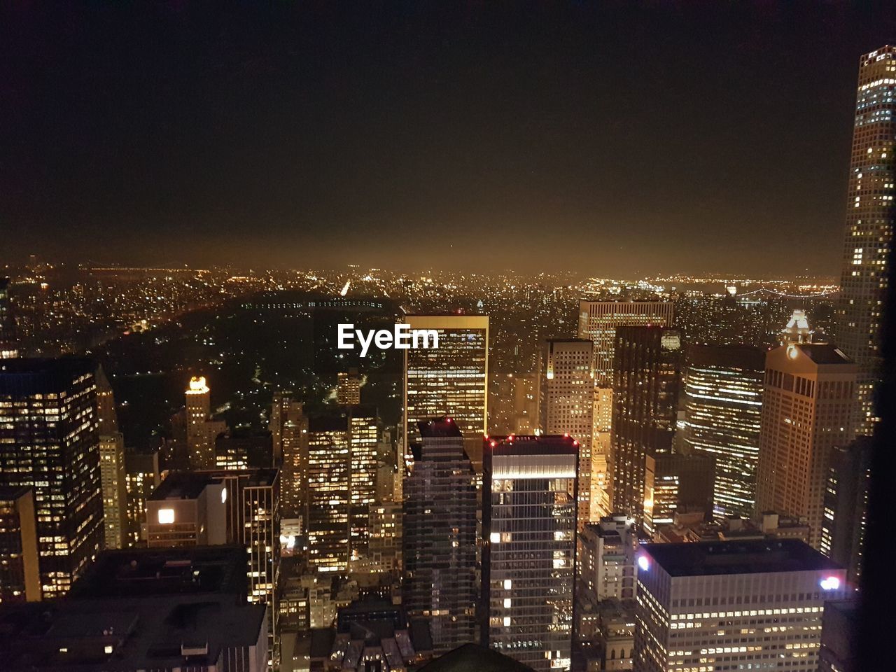 View of illuminated cityscape against blue sky at dusk