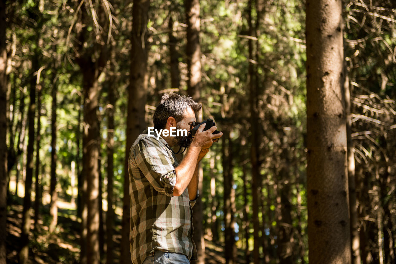 Man photographing in forest