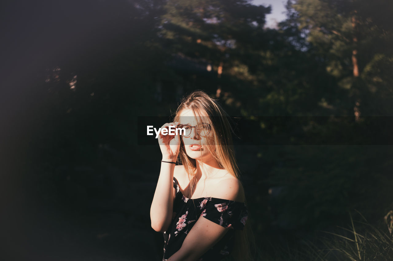 Portrait of woman standing against blurred background