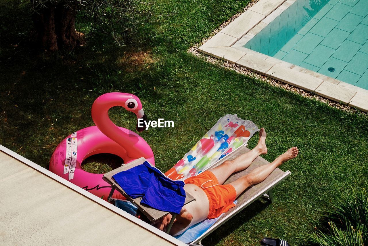 Man relaxing by swimming pool