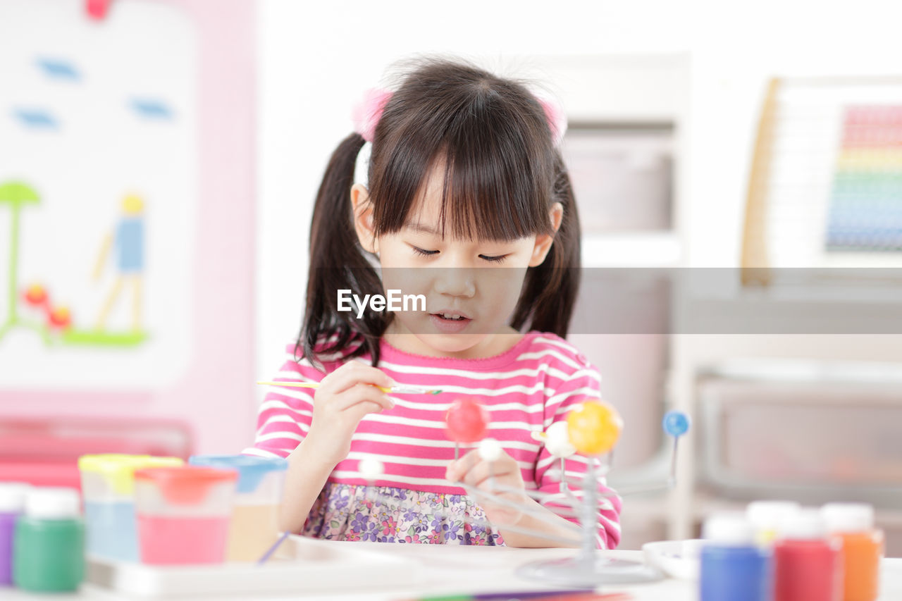 Cute girl painting at home