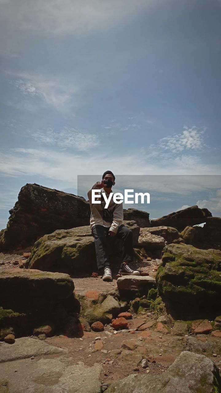 FULL LENGTH OF MAN STANDING ON ROCK