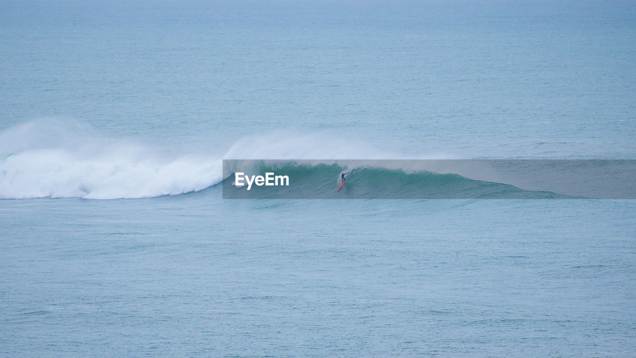 Scenic view of guethary and surfer