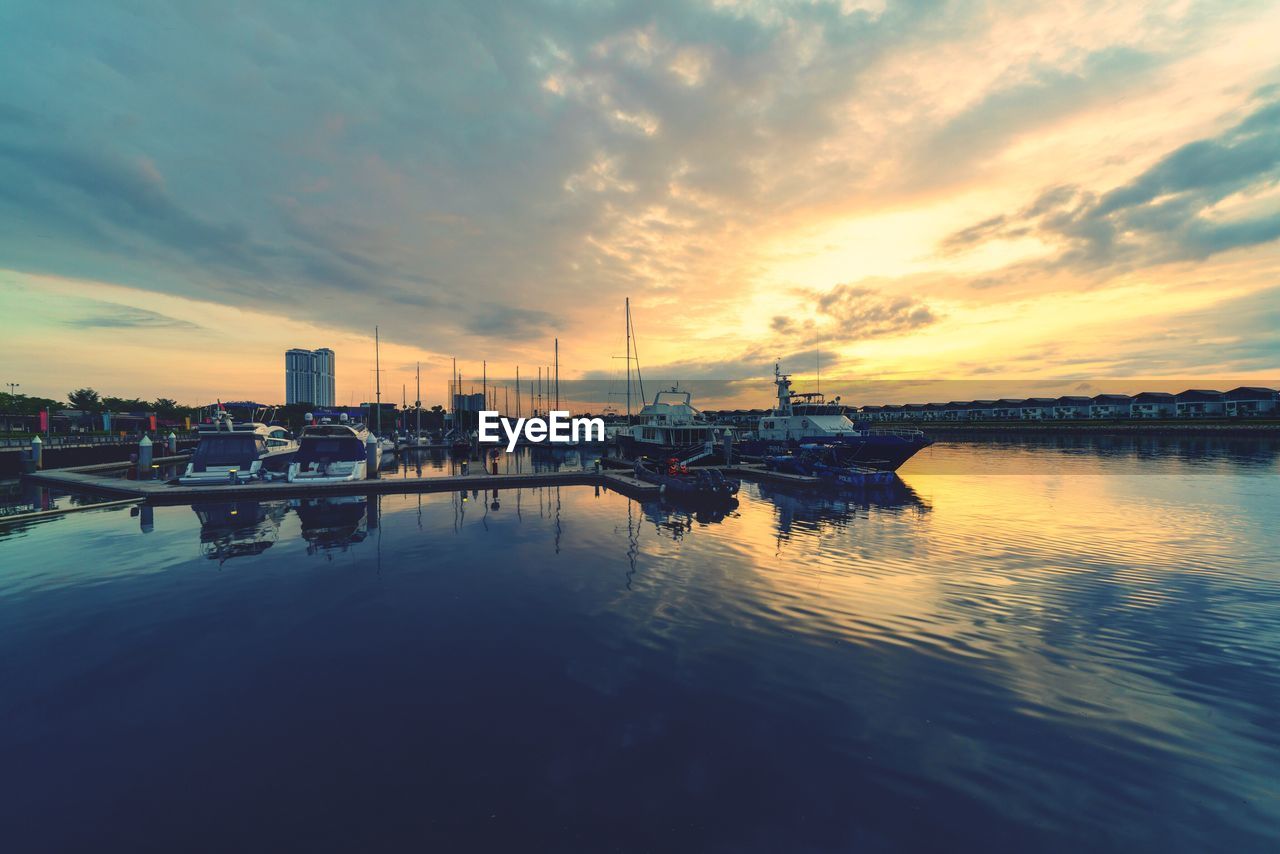 BOATS IN SEA AT SUNSET