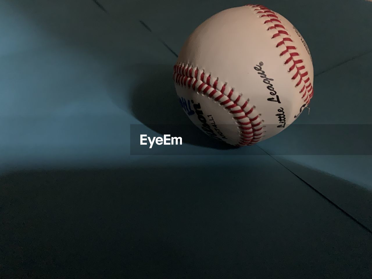 Close-up of baseball on blue background.