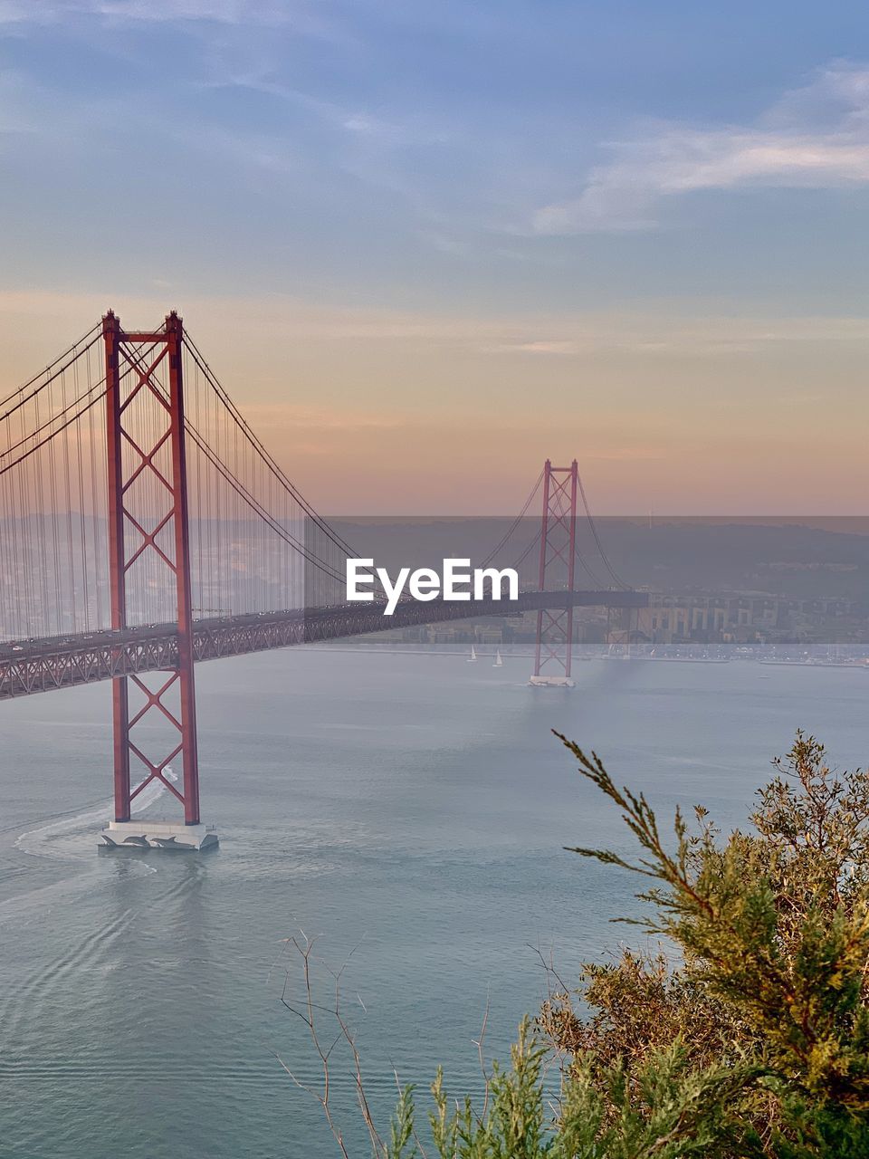 Suspension bridge over sea against sky