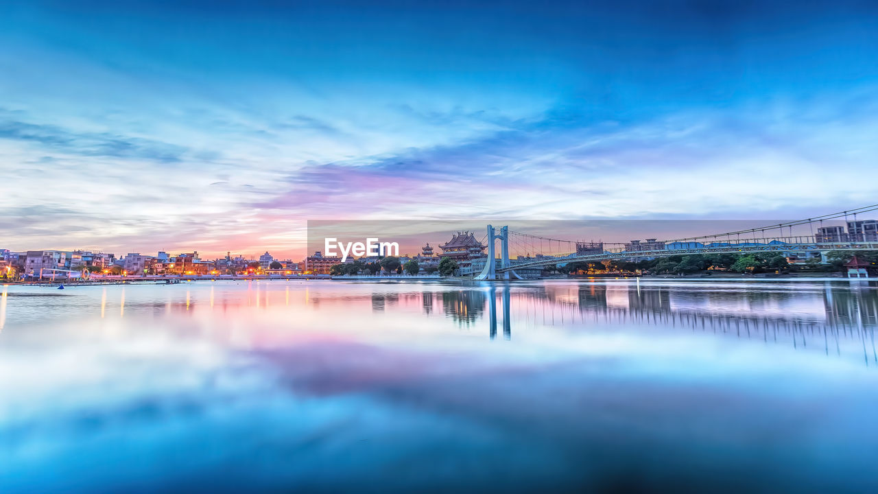 Bridge over river against sky during sunset