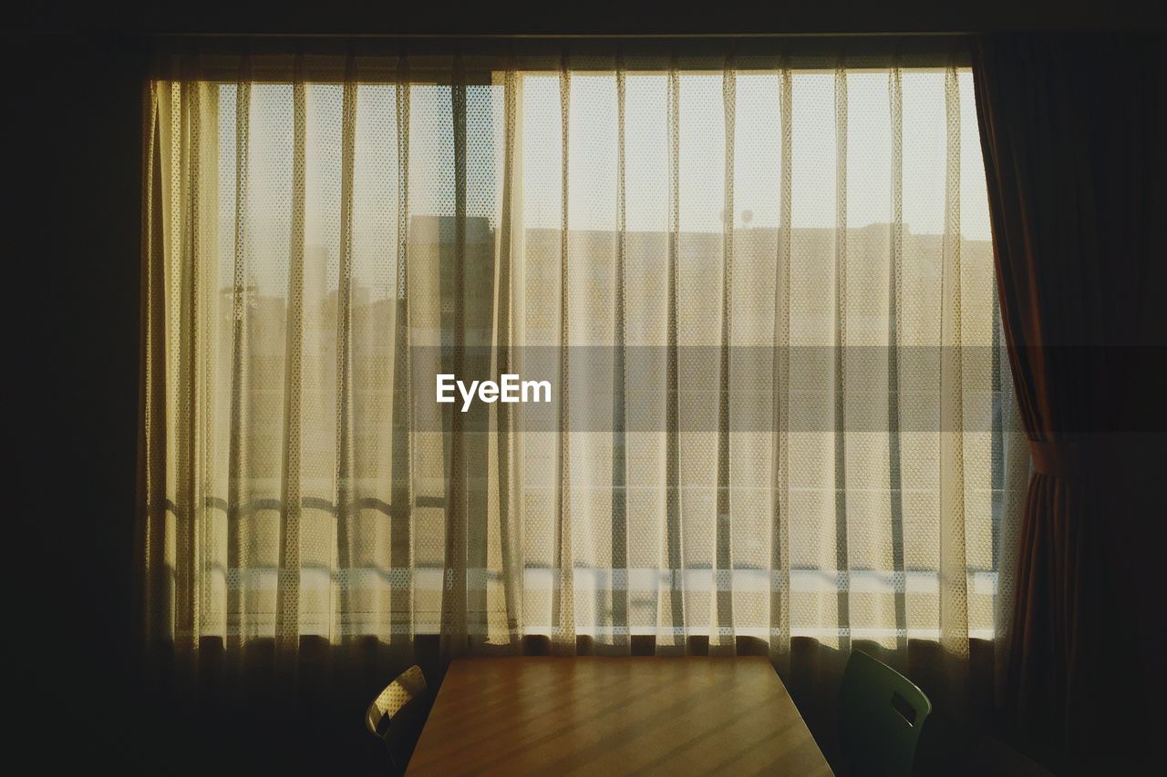 Empty chairs and table by window at home