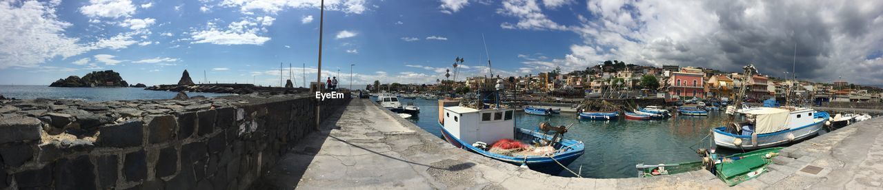 PANORAMIC VIEW OF BOATS MOORED AT HARBOR AGAINST BUILDINGS